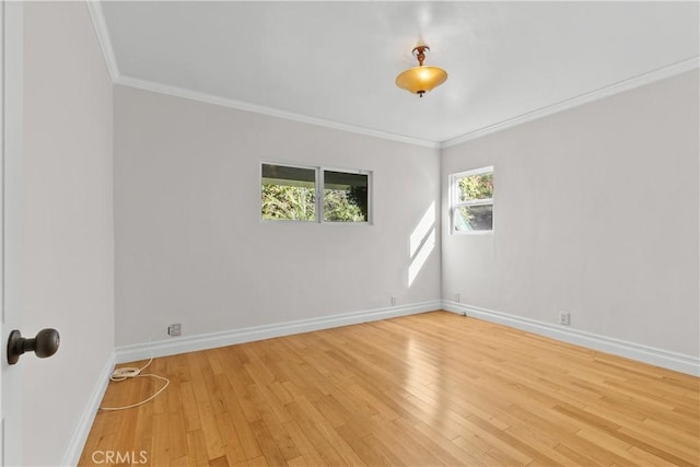 empty room featuring ornamental molding and light hardwood / wood-style flooring