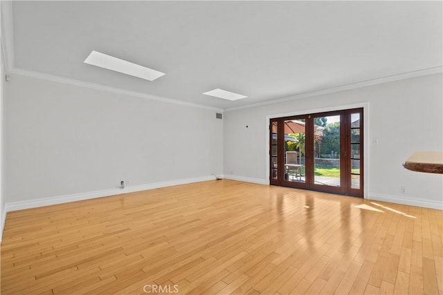 empty room featuring crown molding, light hardwood / wood-style flooring, and french doors