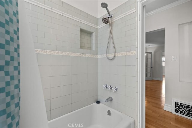 bathroom featuring crown molding, shower / tub combo with curtain, and hardwood / wood-style flooring