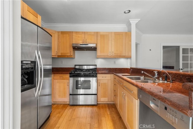 kitchen with stainless steel appliances, crown molding, sink, dark stone countertops, and light hardwood / wood-style floors