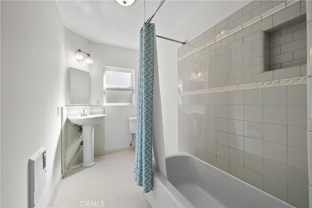 full bathroom featuring sink, tile patterned flooring, heating unit, shower / bath combination with curtain, and toilet