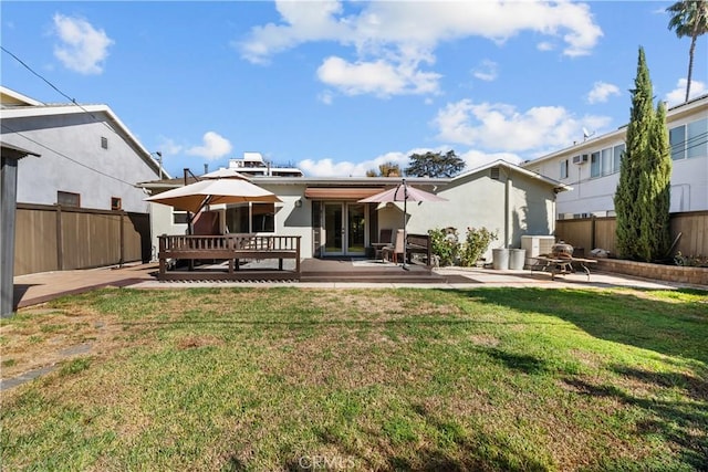 back of house featuring a yard, a patio, and a wooden deck