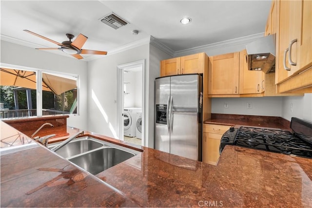 kitchen with range hood, stainless steel refrigerator with ice dispenser, black gas stove, washer and dryer, and ornamental molding