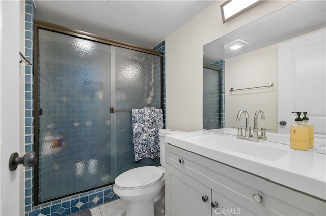 bathroom featuring tile patterned flooring, vanity, a shower with door, and toilet