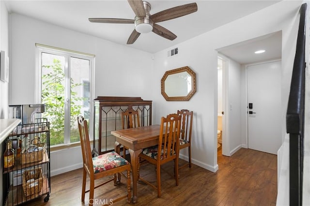 dining room with plenty of natural light, ceiling fan, and dark wood-type flooring