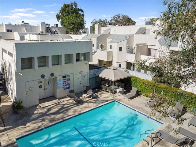 18411 Hatteras St Unit 120, Tarzana, CA 91356 - back of house with stucco siding, a patio, a community pool, and a residential view
