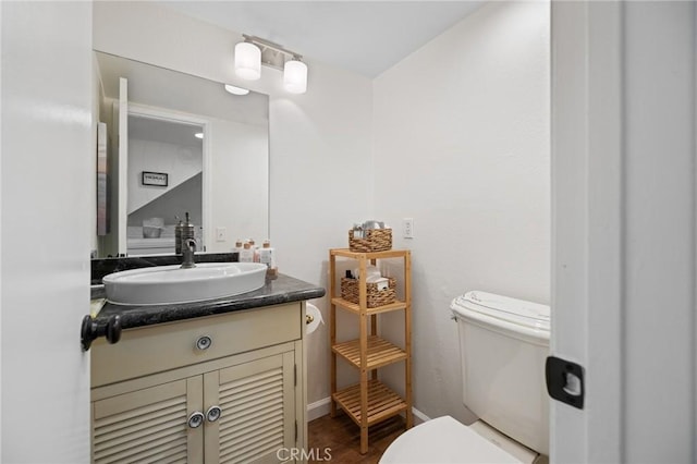 18411 Hatteras St Unit 120, Tarzana, CA 91356 - half bathroom featuring toilet, vanity, wood finished floors, and baseboards