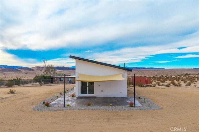 rear view of house featuring a mountain view and a patio