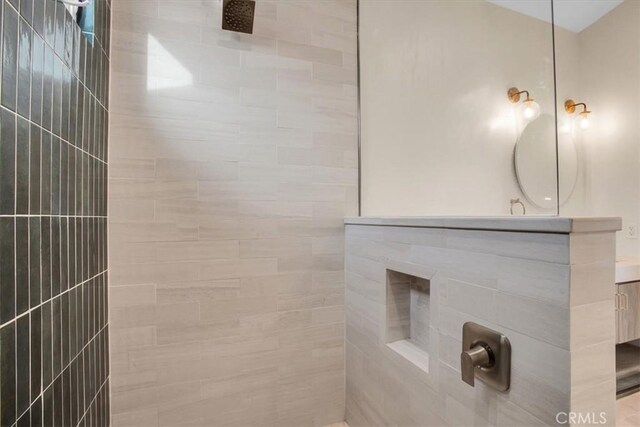 bathroom with vanity and tiled shower