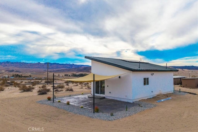 rear view of house with a mountain view and a patio