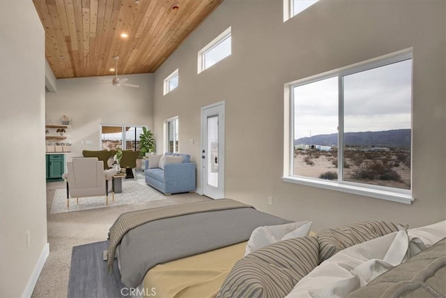 carpeted bedroom featuring a towering ceiling, access to exterior, and wood ceiling