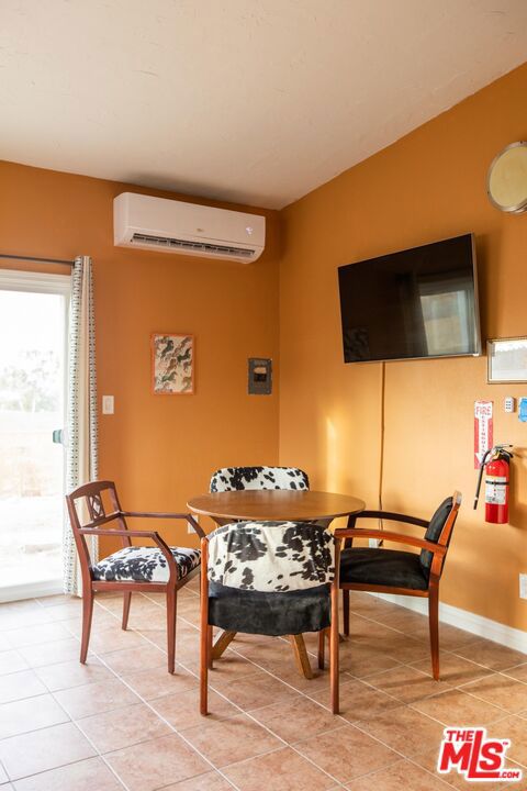 tiled dining room with a wall mounted AC