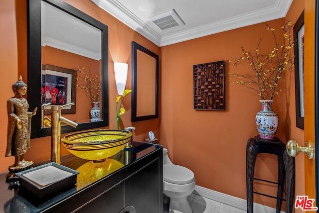 bathroom featuring crown molding, vanity, tile patterned floors, and toilet