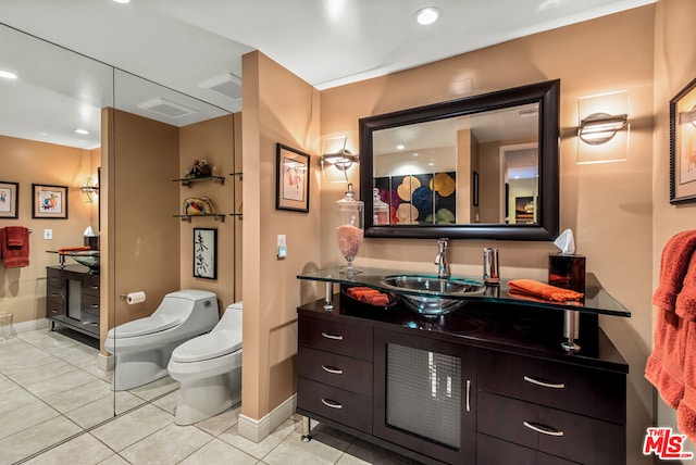 bathroom featuring a bidet, tile patterned floors, toilet, and vanity