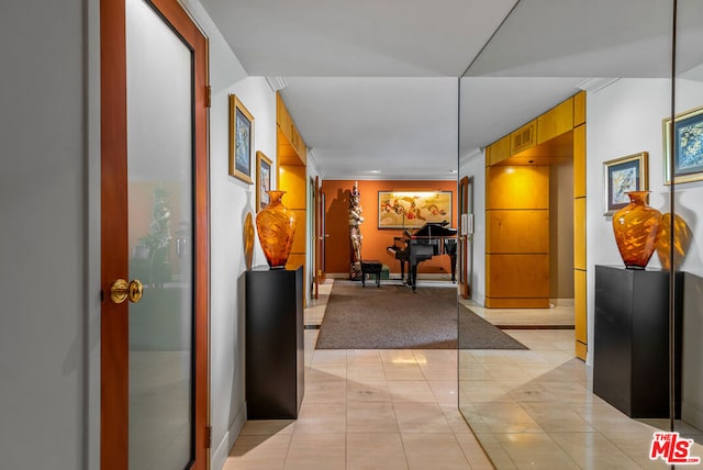 corridor with light tile patterned floors and crown molding