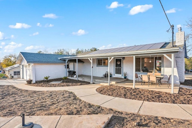 ranch-style house featuring a patio area and solar panels