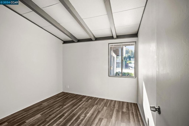 spare room featuring beam ceiling and hardwood / wood-style floors