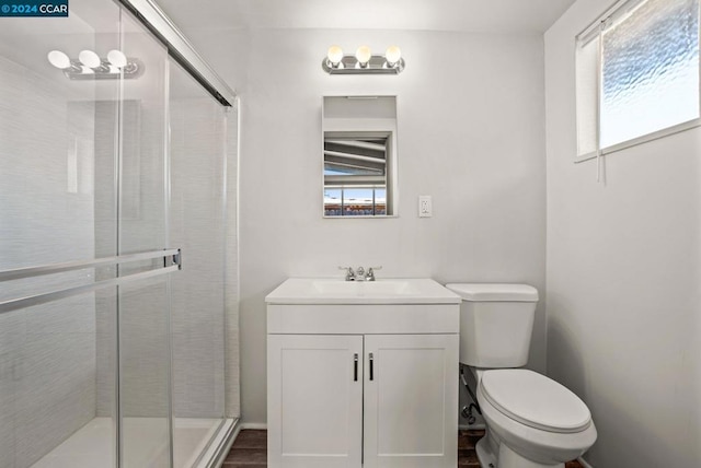 bathroom with vanity, a shower with shower door, hardwood / wood-style flooring, and toilet