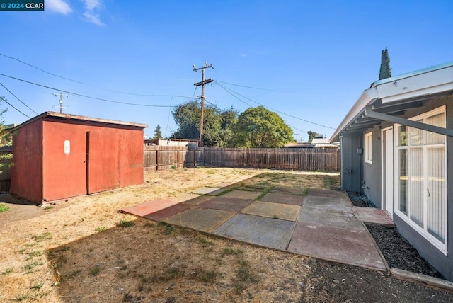 view of yard featuring a shed and a patio