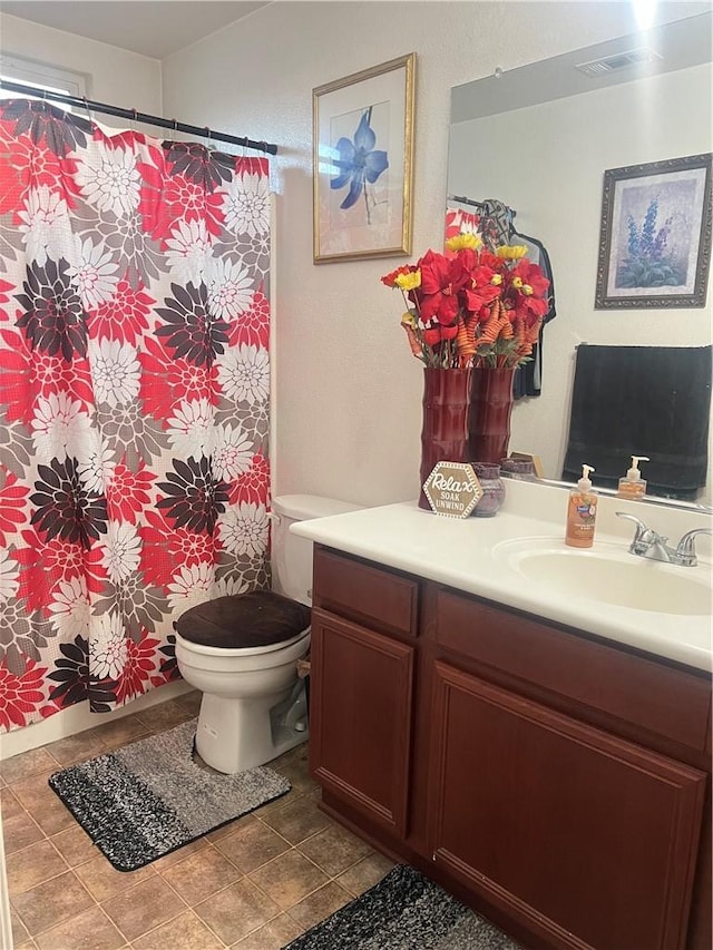 bathroom with tile patterned flooring, vanity, and toilet