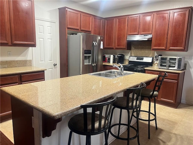 kitchen with gas stove, stainless steel fridge, sink, and a kitchen bar