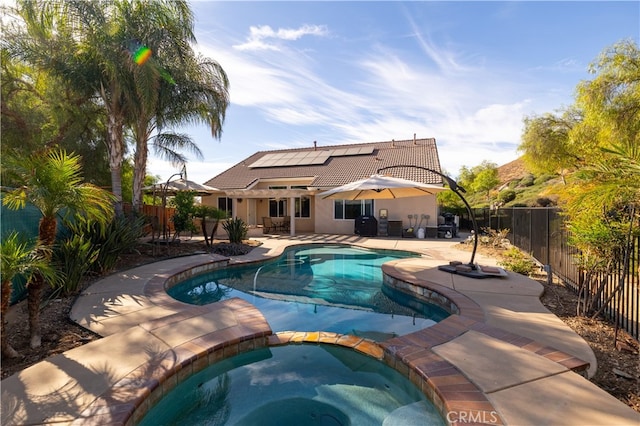 view of swimming pool featuring a patio area and an in ground hot tub