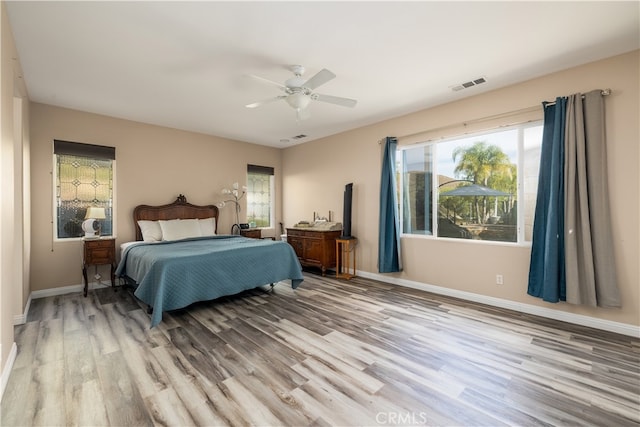 bedroom featuring multiple windows, light wood-type flooring, and ceiling fan