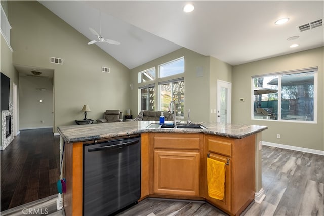 kitchen with black dishwasher, sink, a center island with sink, and hardwood / wood-style floors