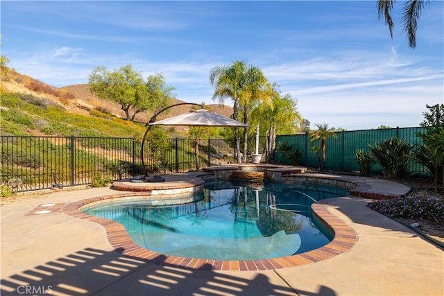 view of swimming pool with a patio and an in ground hot tub