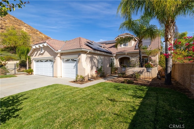 view of front of property with a front yard, solar panels, and a garage