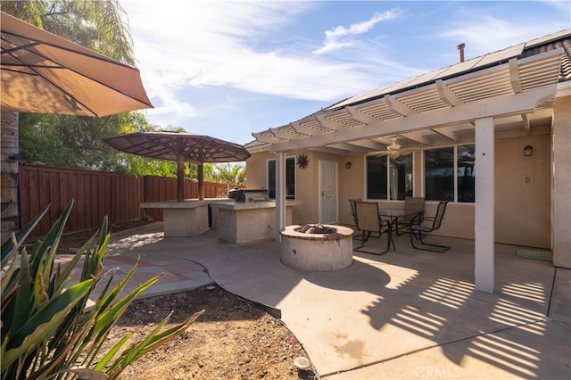 view of patio with area for grilling, a fire pit, and a pergola