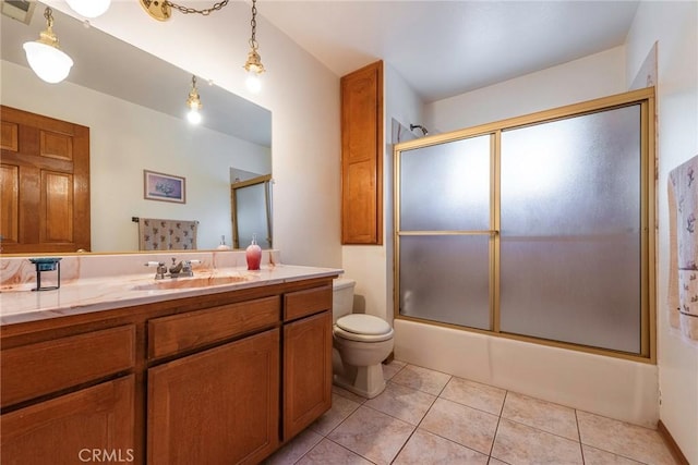 full bathroom with tile patterned floors, toilet, combined bath / shower with glass door, and vanity