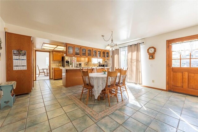 dining space featuring plenty of natural light, light tile patterned flooring, and an inviting chandelier