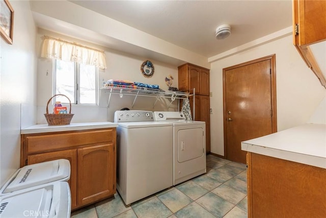 washroom featuring cabinets, light tile patterned floors, and washing machine and clothes dryer