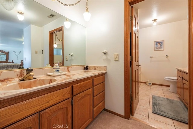 bathroom with tile patterned flooring, vanity, and toilet