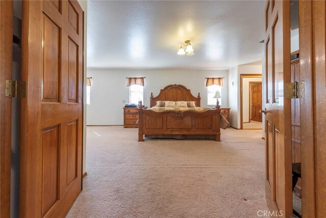 carpeted bedroom featuring a notable chandelier