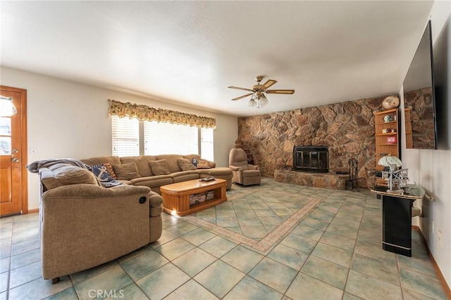 tiled living room featuring ceiling fan and a wood stove