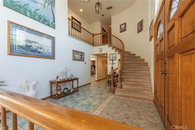 tiled entryway featuring a high ceiling