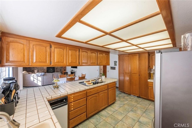 kitchen with white electric cooktop, stainless steel fridge, tile countertops, and kitchen peninsula