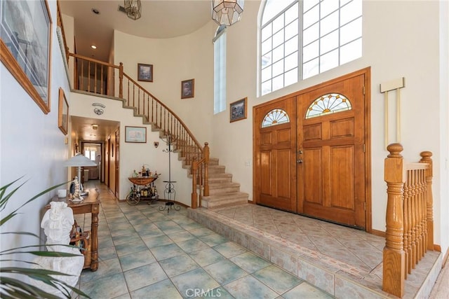 tiled entryway featuring a towering ceiling