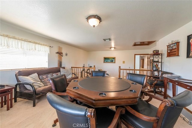 rec room featuring a textured ceiling and light colored carpet