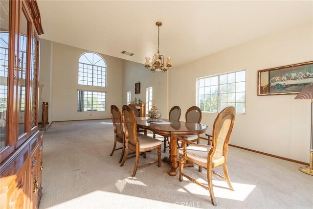 carpeted dining area featuring an inviting chandelier