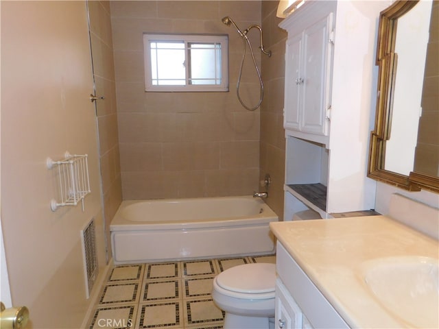 full bathroom featuring tiled shower / bath, vanity, and toilet