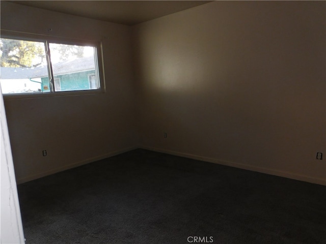 unfurnished room with dark carpet