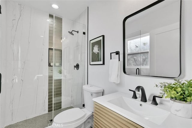 bathroom featuring vanity, toilet, and a shower with door