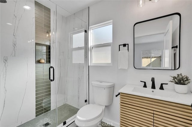 bathroom featuring vanity, a healthy amount of sunlight, toilet, and walk in shower