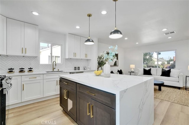 kitchen with white cabinets, sink, and light hardwood / wood-style flooring