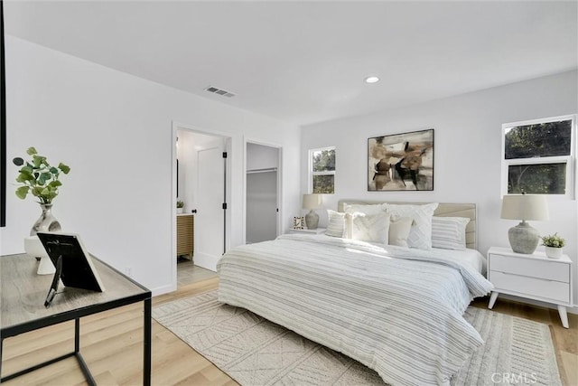 bedroom featuring light hardwood / wood-style floors and multiple windows