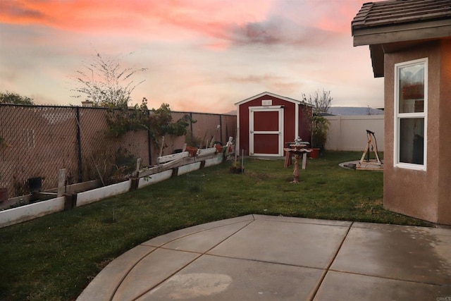 yard at dusk with a patio and a shed