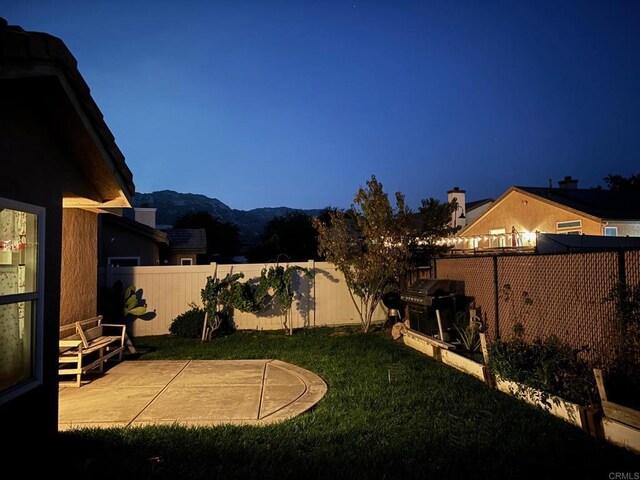 view of yard featuring a patio area and a mountain view